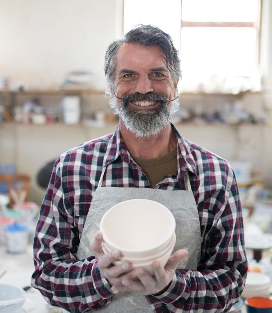 Inicio 8 proud male potter showing his creation to camera i R8N3WTD